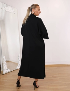 Back view of a long black dress with slit detail and high-fashion standing collar