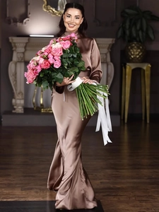 Elegant bronze satin maxi dress with high neck and mermaid silhouette in luxury interior