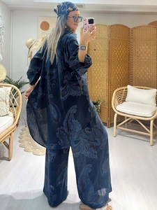 Detailed view of the dark blue paisley printed shirt and wide-leg pants on a model