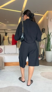 Détail de l'ensemble noir avec haut à manches chauve-souris et short à taille haute