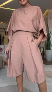 Détail du haut à manches chauve-souris rose et short taille haute avec texture en lin