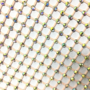 Detail of nude mesh fabric featuring sparkling AB rhinestones on a fishnet long sleeve top