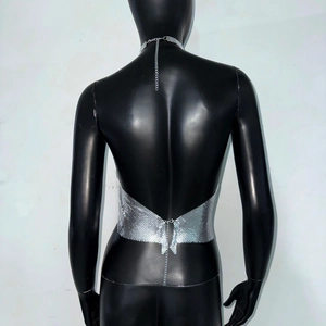 Macro detail of silver sequin halter top featuring fine metal mesh and chain closure