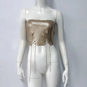 Détail du haut en maille métallique dorée avec boucles d'anneaux et fines chaînes pendantes