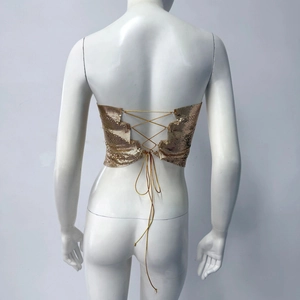 Détail du haut court à paillettes dorées dos nu avec fines chaînes croisées réglables