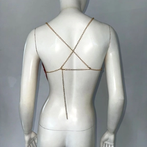 Detail of gold metal body chain featuring an X-shaped back cross and fine chain links