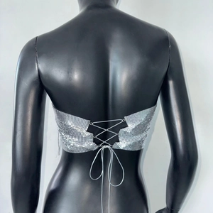 Détail d'un haut à paillettes argentées avec un design lacé ajustable dans le dos