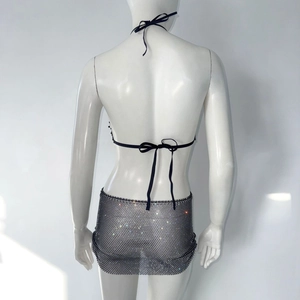 Detail van zwarte mesh set met haltertop en minirok voorzien van glimmende strass