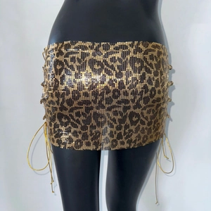 Dettaglio mini gonna leopardata in paillettes metalliche con lacci dorati laterali