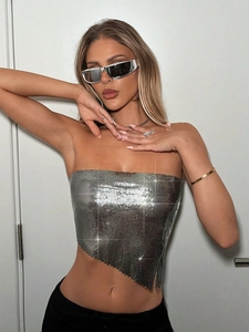 Detailaufnahme des silbernen Pailletten-Metallnetz-Tops mit asymmetrischem Saum und Reflexionen