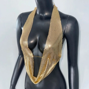 Détail d'un haut dos nu en maille dorée avec décolleté en V plongeant et sequins brillants