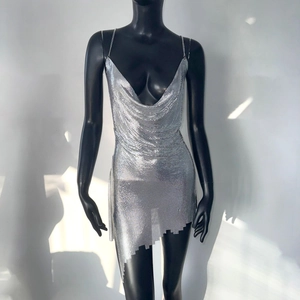 Macro detail of silver metal mesh fabric and delicate chain straps on a sequin dress