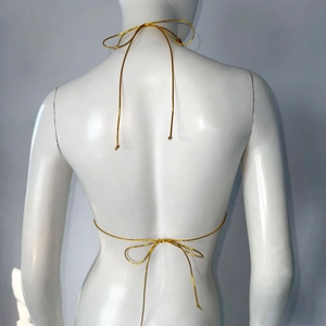Back view of a gold metallic halter top with thin crossover strings and bow ties