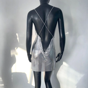 Detail of silver sequin dress showing backless cut and X-shaped metal chain straps