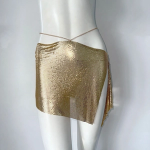 Detalle de minifalda de lentejuelas de metal dorado con cinturón de cadena para fiesta