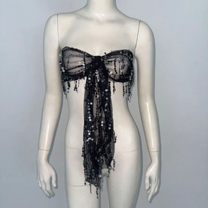 Detail of black mesh sequin tube top with large bow shape and hanging beaded tassels