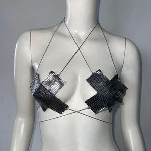 Dettaglio del top allacciato al collo con paillettes metalliche e maglia a croce