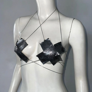 Dettaglio del top corto in maglia di paillettes metalliche nere con catene sottili