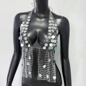 Détail du haut dos nu à sequins argentés avec des disques métalliques réfléchissants