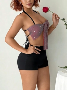 Red bow crop top with pearls and black high-waisted shorts for festival parties