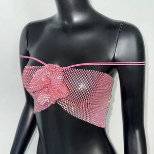 Détail d'un haut en résille à strass roses avec nœud 3D sur un mannequin noir élégant