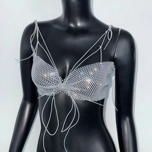 Détail d'un haut en résille à strass argentés avec lacets réglables sur un mannequin noir