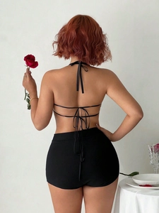 Elegant women's black halter neck bow top and high-waisted shorts set for party wear