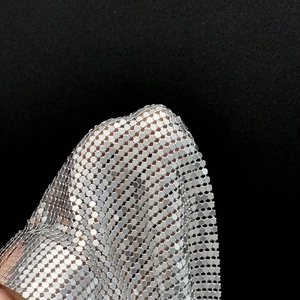 Détail de maille métallique argentée avec paillettes réfléchissantes pour tenue de fête