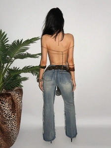 Golden sequin body chain crop top paired with high-waisted flared jeans and accessories