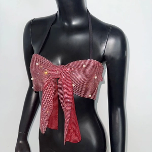 Close-up of red rhinestone bow top with white pearls and black halter neck strap