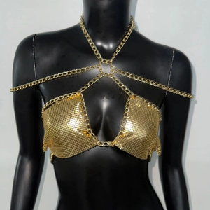 Close-up of golden metallic sequin halter top with chain straps for festival wear
