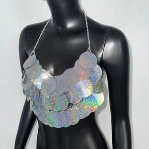 Détail des paillettes argentées holographiques et chaînes sur le top dos nu sexy