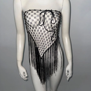 Detail showing black mesh bustier with sparkling rhinestones and long fringe tassels