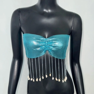 Detail of teal sequin tube top featuring metallic fringe tassels and white shell pendants