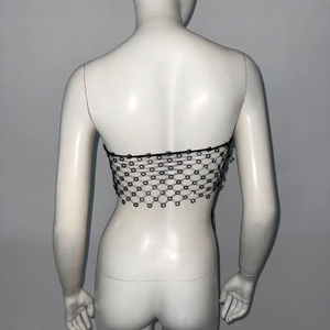Detail of black rhinestone fishnet top featuring floral mesh patterns and bead tassels