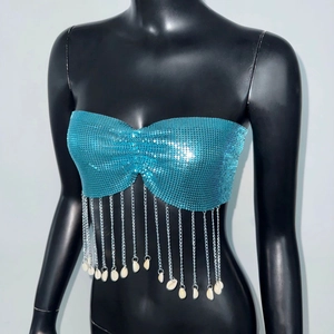 Detail of blue sequin bustier top featuring silver metal chains and shell pendants