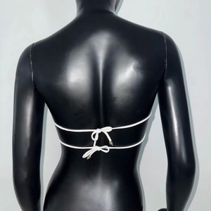Détail d'un haut de bikini blanc montrant des doubles bretelles et des boucles en métal