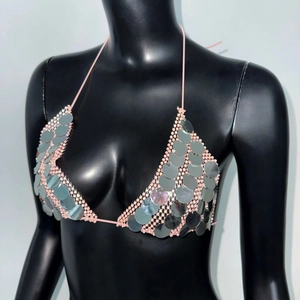 Close-up of silver sequins and pink halter neck ties on a festive mesh crop top