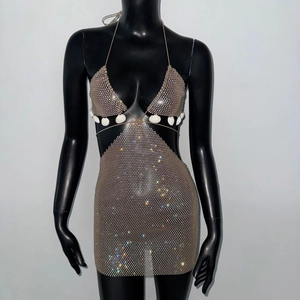 Détail d'une robe en maille à paillettes avec strass et ornements délicats en coquillage