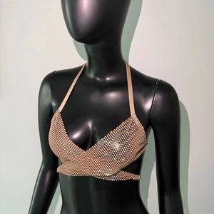 Macro detail of sparkling rhinestones on golden mesh halter top for party wear