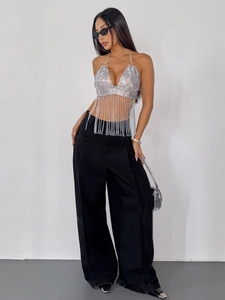 Dettaglio del top all'americana con paillettes argento e pantaloni neri a gamba larga