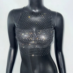 Detail eines sexy Neckholder-Netzoberteils mit funkelnden Strasssteinen auf schwarzem Netz
