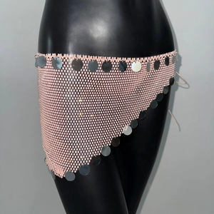 Dettaglio di minigonna rosa a rete con strass e paillettes argentate