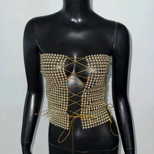 Detailed macro shot of iridescent rhinestone halter top with golden lace-up design