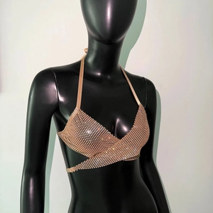 Detail of gold rhinestone halter top featuring cross tie straps and shimmering finish