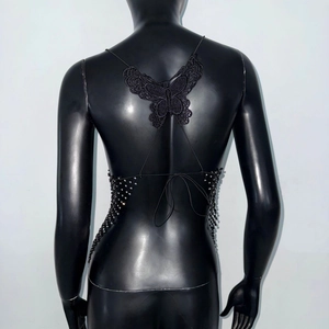 Exquisite back detail of a black beaded top featuring a lace butterfly applique design