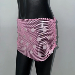 Détail d'une mini-jupe en résille rose avec de grandes paillettes rondes pour la fête
