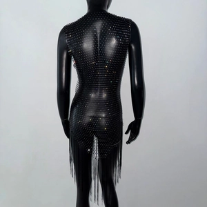 Dettaglio dell'abito a rete nero con strass colorati e lunghe nappe a frangia