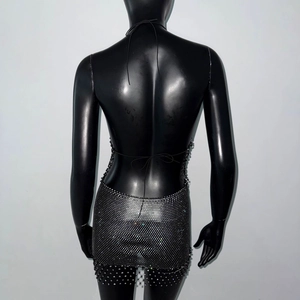 Detail of black rhinestone halter dress with open back ties and sparkling fringe