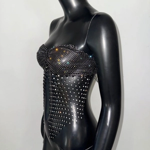 Vista laterale dettagliata del top nero a rete con strass scintillanti e frange a maglia